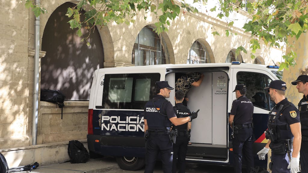 Polizisten stehen um den Transport, in dem die Verdächtigen zum Termin mit dem Haftrichter auf Mallorca gebracht wurden.&nbsp;