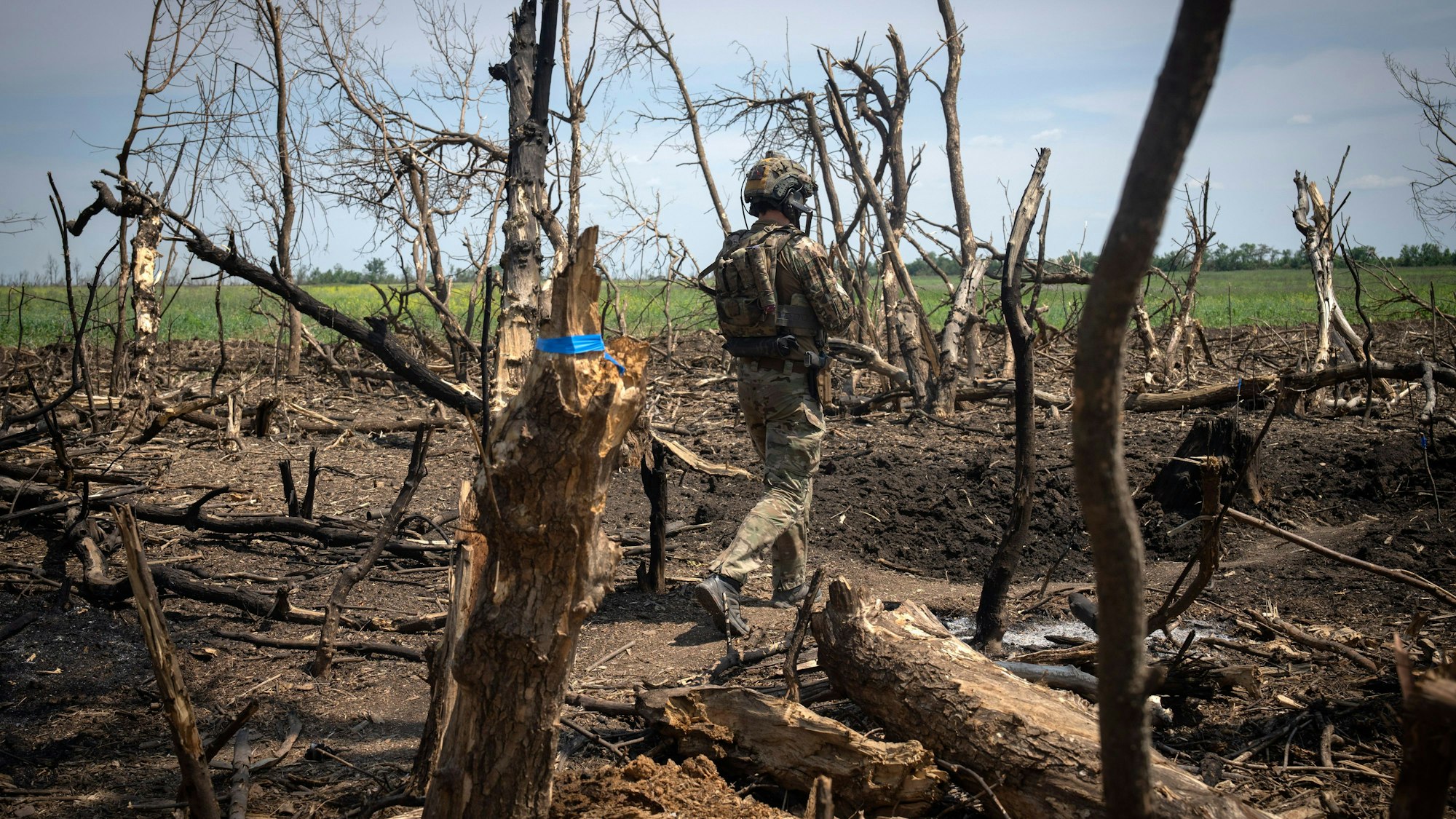 Ein ukrainischer Soldat läuft Ende Juni vorsichtig über ein Minenfeld an der Front in Saporischschja.