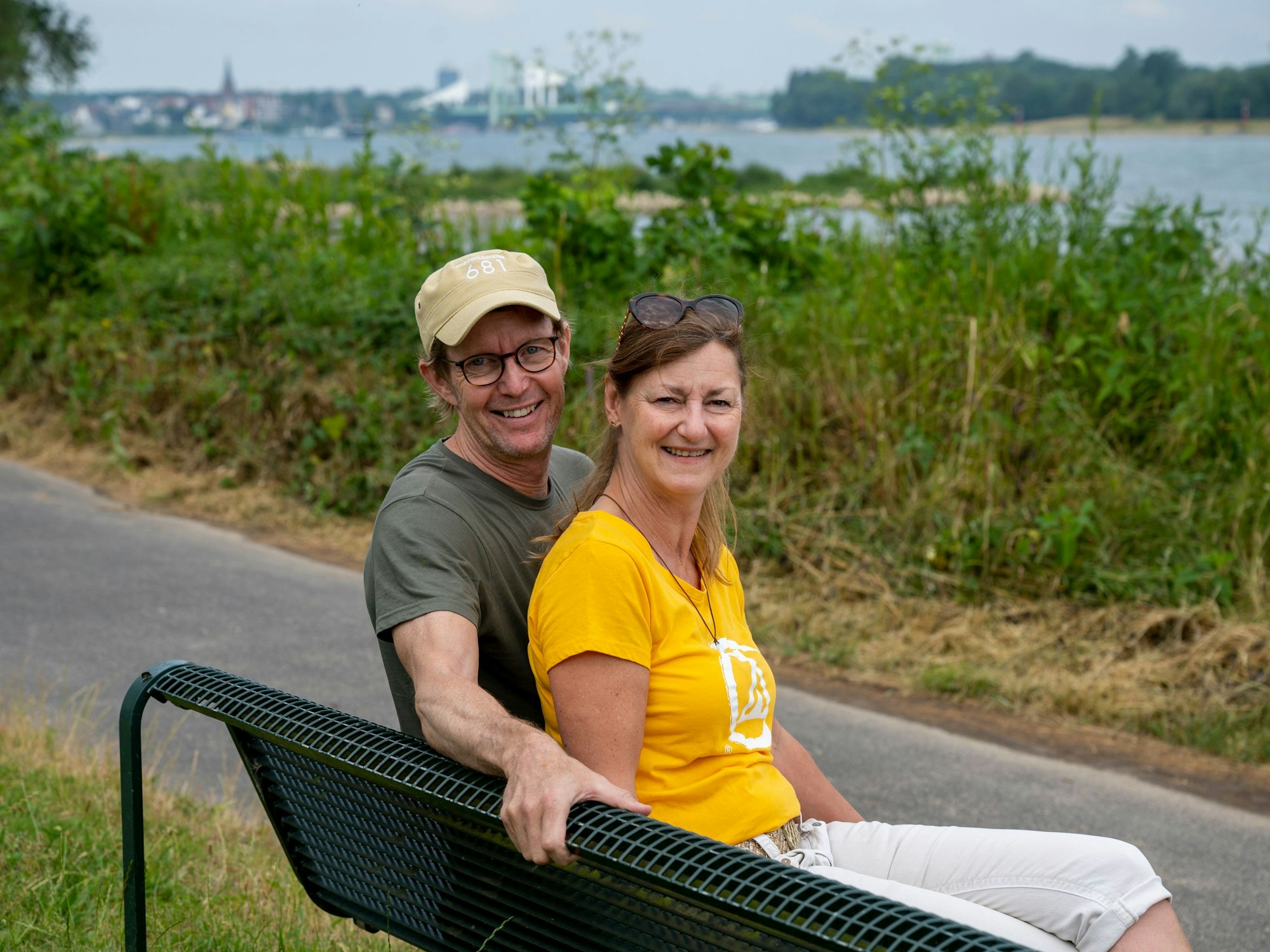 Bernhard und Susanne Berger sitzen auf einer Bank am Rodenkirchener Rheinufer.
