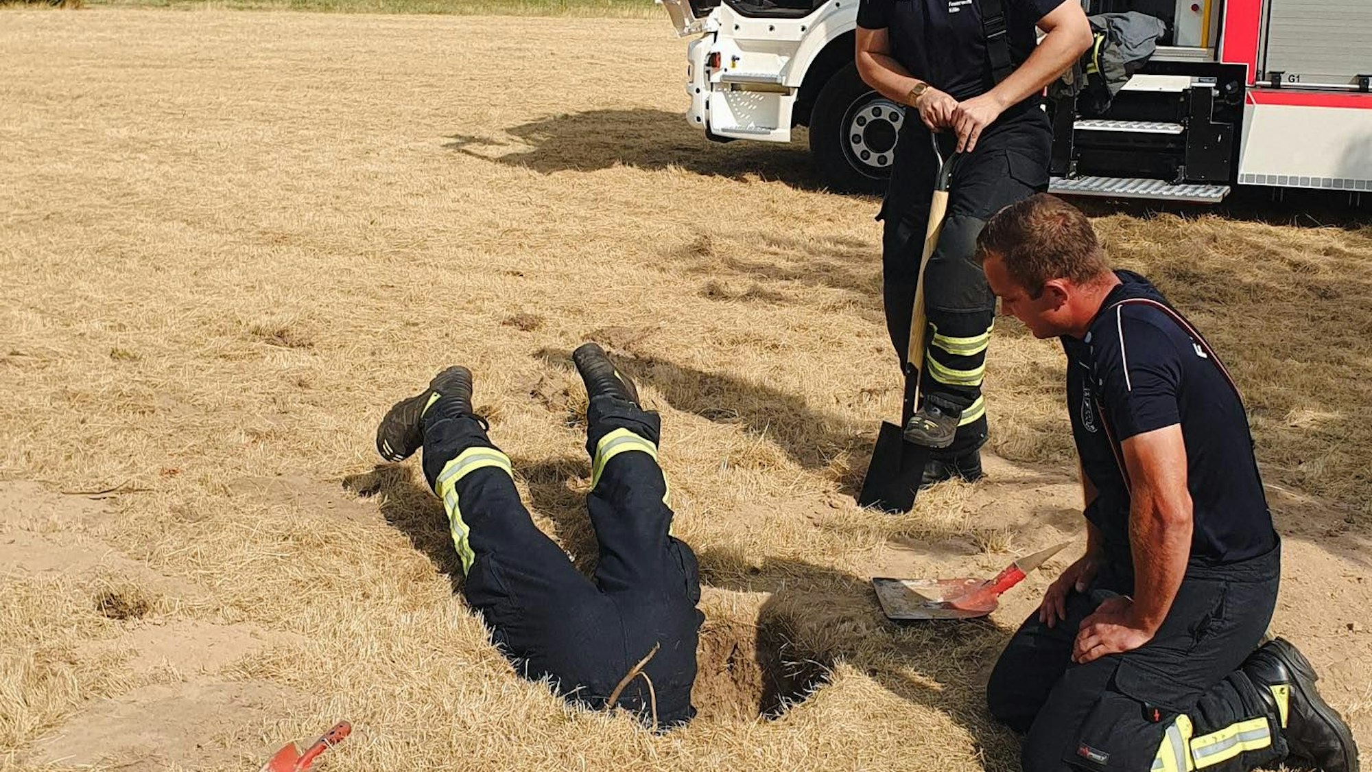 Einsatzkräfte der Feuerwehr retten einen Hund auf einem Sportfeld in Chorweiler aus einem Kaninchenbau.
