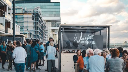 Menschen amüsieren sich beim Weinfest am Kölner Rheinauhafen