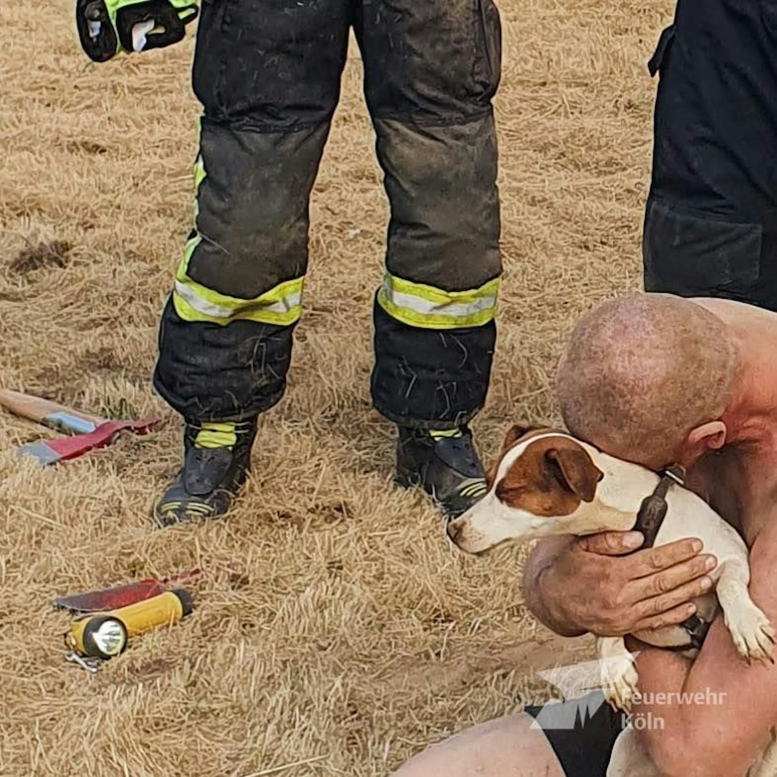 Der Besitzer des Jack Russell Terriers hält seinen befreiten Hund wieder im Arm.