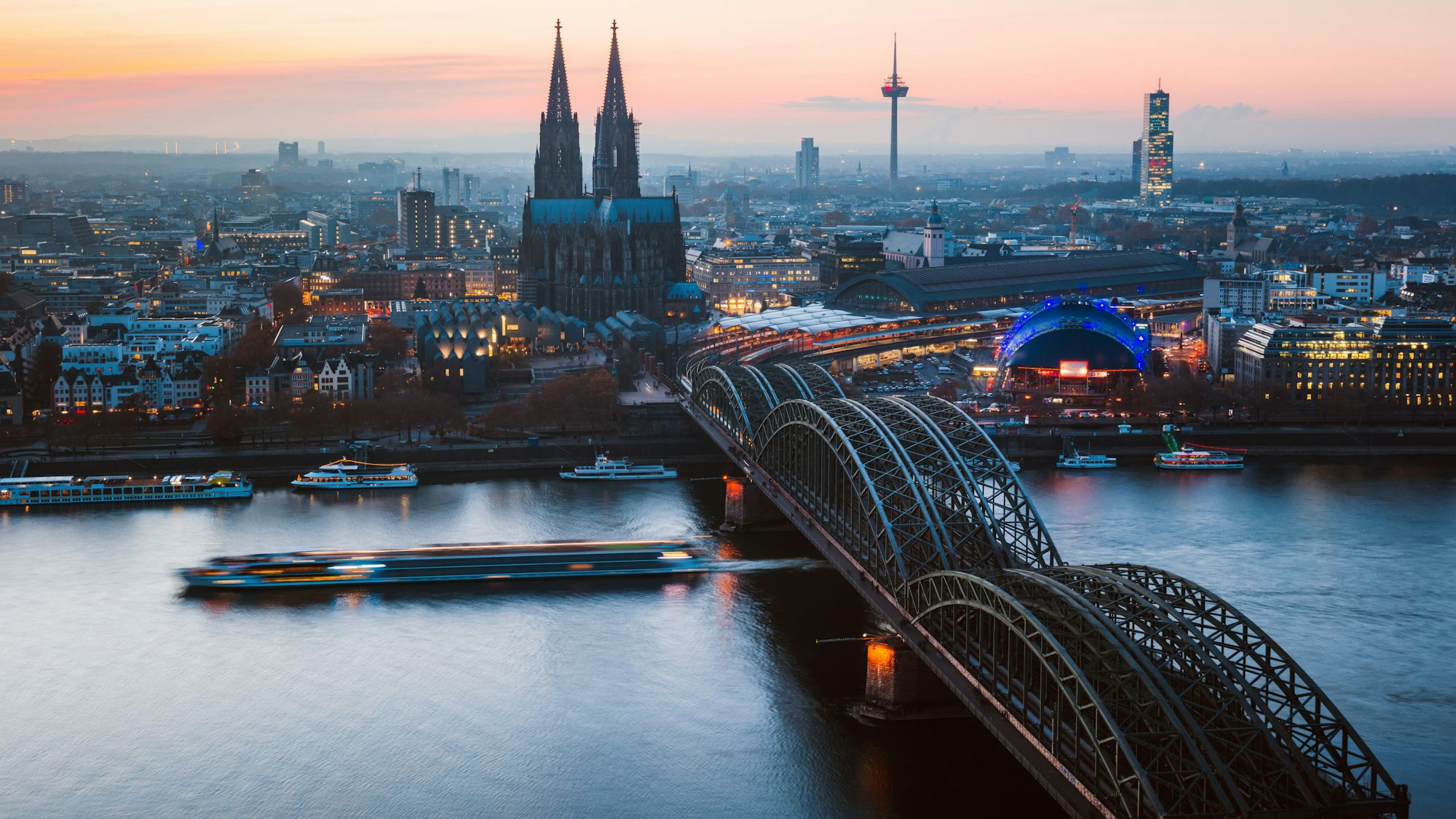 Das Bild zeigt die Hohenzollernbrücke und den Kölner Dom, dahinter der Blick Richtung Westen.