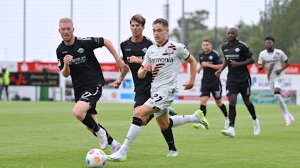 Bayer-04-Test gegen Paderborn: Florian Wirtz (in weiß) schüttelt Paderborns Kai Klefisch und Maximilian Rohr ab.