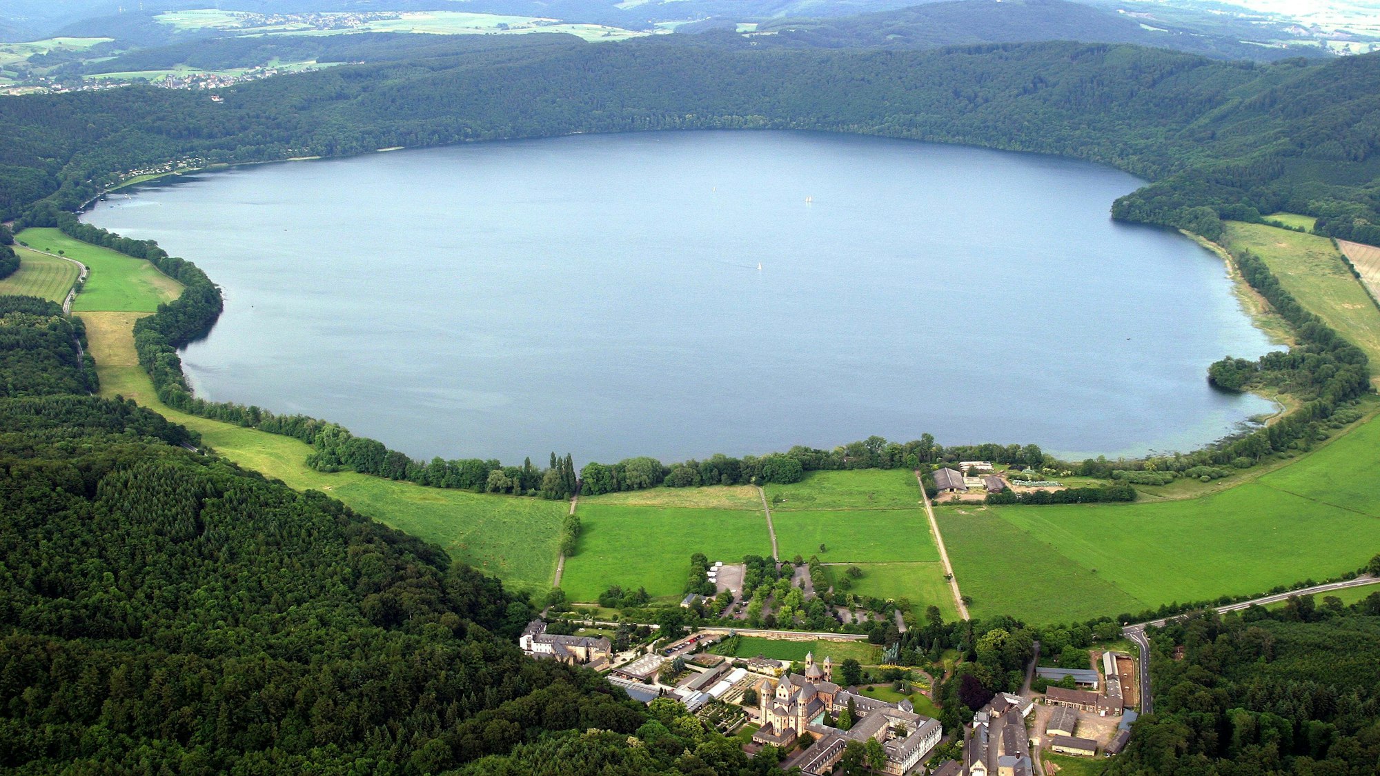 Luftbild von Mendig mit dem Laacher See und dem Kloster Maria Laach in der Eifel. Aufnahme von 2004.