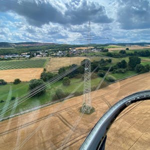 Das Bild zeigt einen Blick aus einem Hubschrauber auf eine 380-kV-Stromleitung bei Kalenberg.