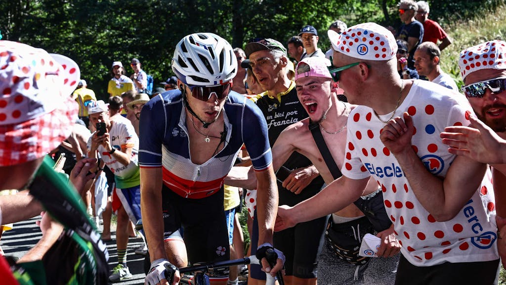 Valentin Madouas fährt bei der Tour de France zwischen jubelnden Fans einen Anstieg hoch.