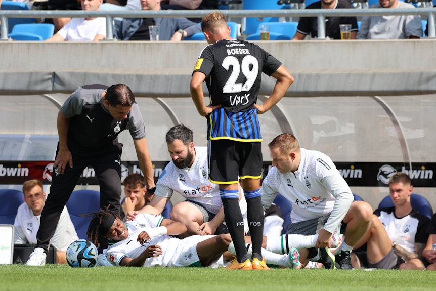 Yvandro Borges Sanches (liegend) muss im Testspiel von Borussia Mönchengladbach beim 1. FC Saarbrücken behandelt werden.