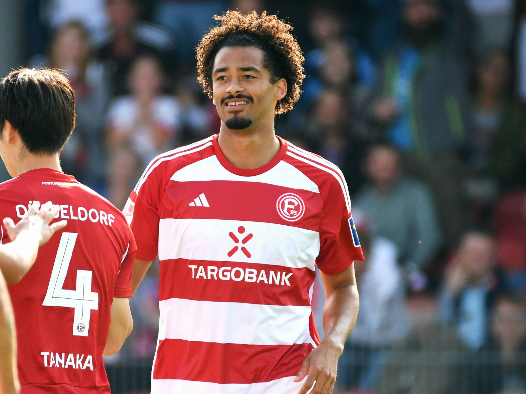 Emmanuel Iyoha lächelt bei einem Spiel von Fortuna Düsseldorf.