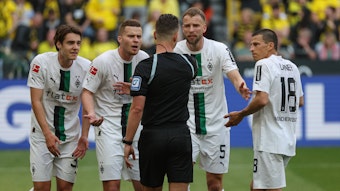 Spieler von Borussia Mönchengladbach beschweren sich im Spiel bei Borussia Dortmund am 13. Mai 2023 beim Schiedsrichter Daniel Schlager.