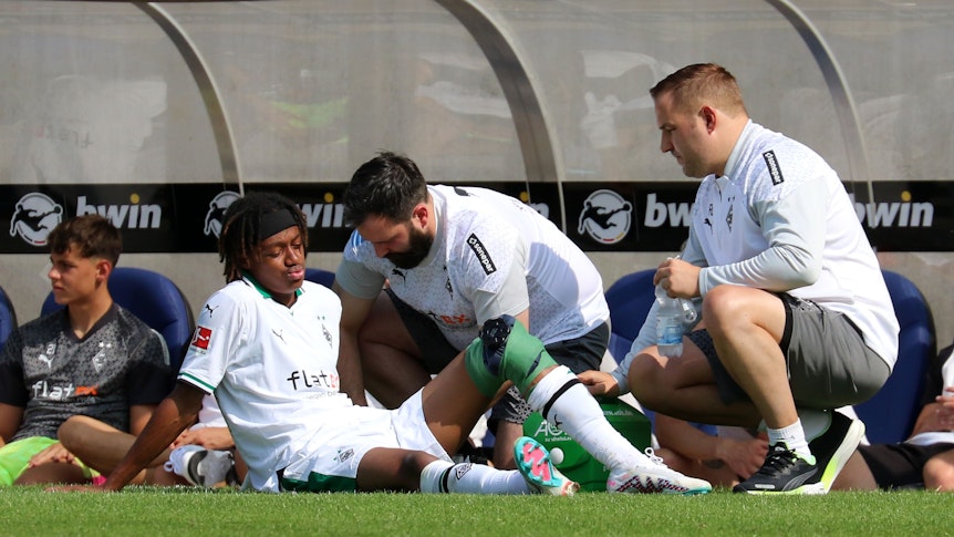 Yvandro Borges Sanches wird während des Testspiels von Borussia Mönchengladbach beim 1. FC Saarbrücken am 22. Juli 2023 am Spielfeldrand behandelt. Sein linkes Knie ist bandagiert.