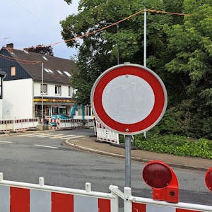 Ein Durchfahrt-verboten-Schild steht hinter einer Warnbake, die die komplette Straße in einem Kreisverkehr absperrt.