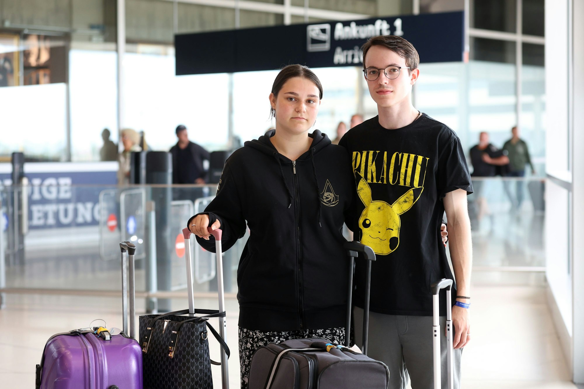 Vanessa Ewertz und Miguel Lexis
stehen am Ankunftsgate des Köln-Bonner Airports.
