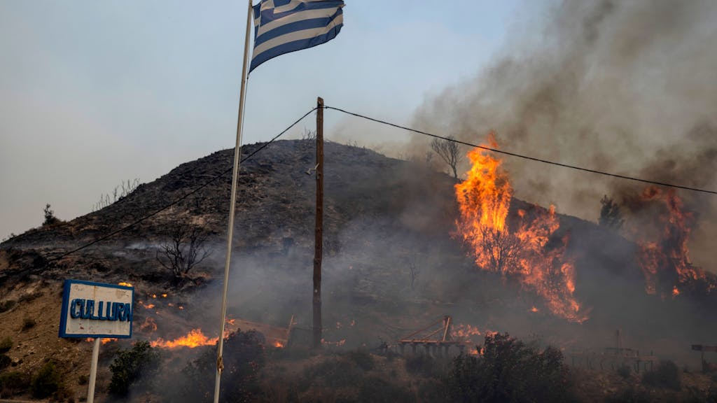 Flammen lodern auf einem Hügel in Griechenland.