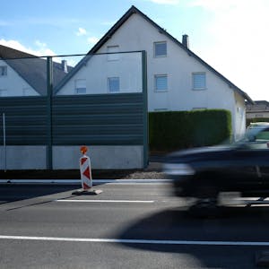 Das Foto zeigt einen Pick-up, der auf einer zweispurigen Straße an Häusern vorbeifährt.&nbsp;