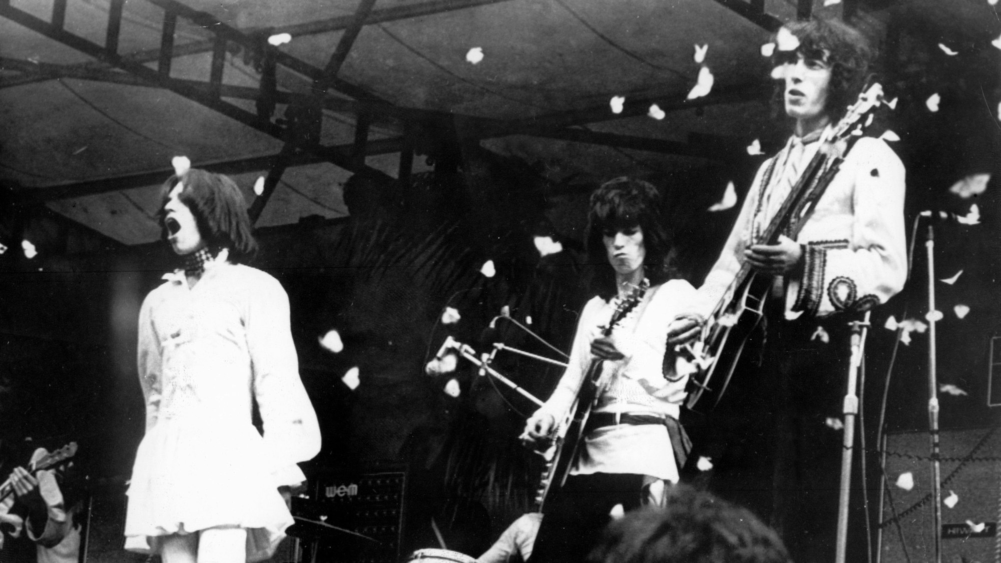 ARCHIV - 05.07.1969, Großbritannien, London: Frontman Mick Jagger (l-r), Rond Wood und Keith Richards von den Rolling Stones stehen auf der Bühne im Hyde Park, während Tausende von freigelassenen Schmetterlingen sie umschwärmen. (zu dpa-Korr "Vor 60 Jahren: Die Stones spielen in London ihr erstes Konzert") Foto: UPI/dpa +++ dpa-Bildfunk +++