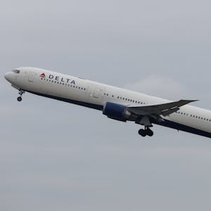 Eine Boeing 767 der US-amerikanischen Fluggesellschaft Delta Airlines startet in die Luft. Im Hintergrund kündigt sich ein Unwetter an. (Symbolbild)
