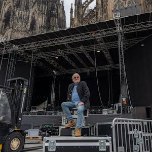 Ernst-Ludwig Hartz sitzt vor der Bühne, auf der ab Mittwoch Weltstars im Schatten des Doms spielen.