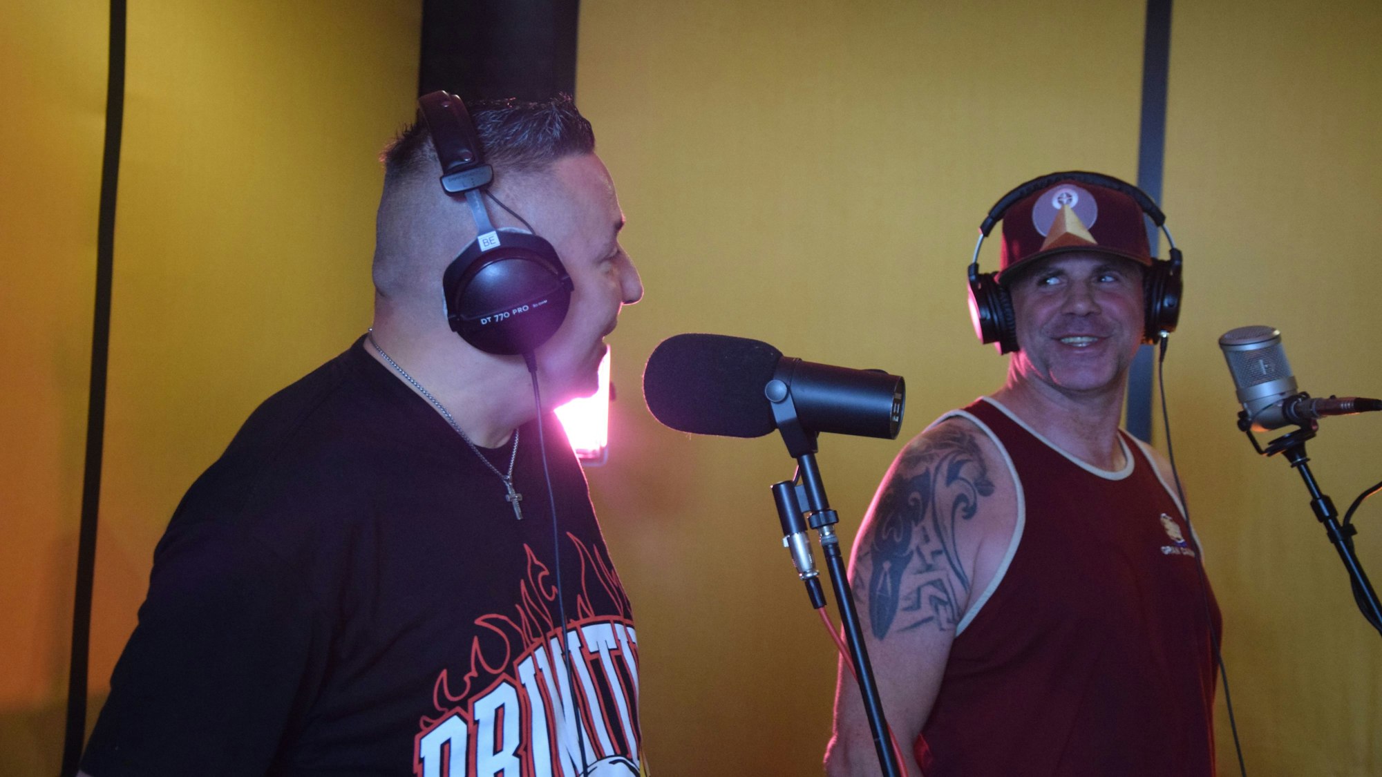 Die Rapper Adelsmann (links) und Hans Solo stehen gemeinsam im Studio und gucken sich, lächelnd an.