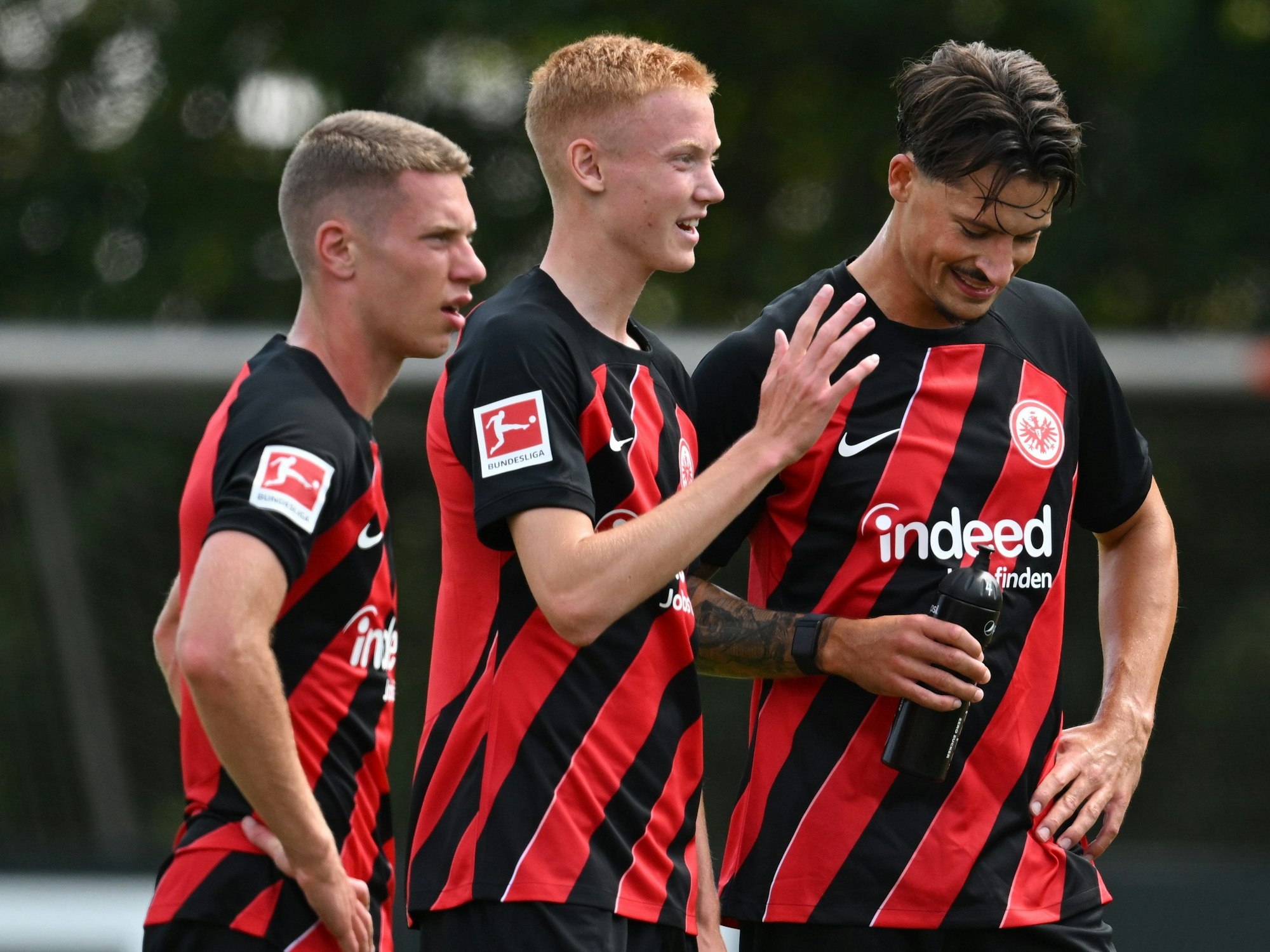 Elias Baum (l-r) und die Neuzugänge Hugo Larsson und Robin Koch stehen beim offiziellen Trainingsauftakt von Eintracht Frankfurt im Stadion zusammen.