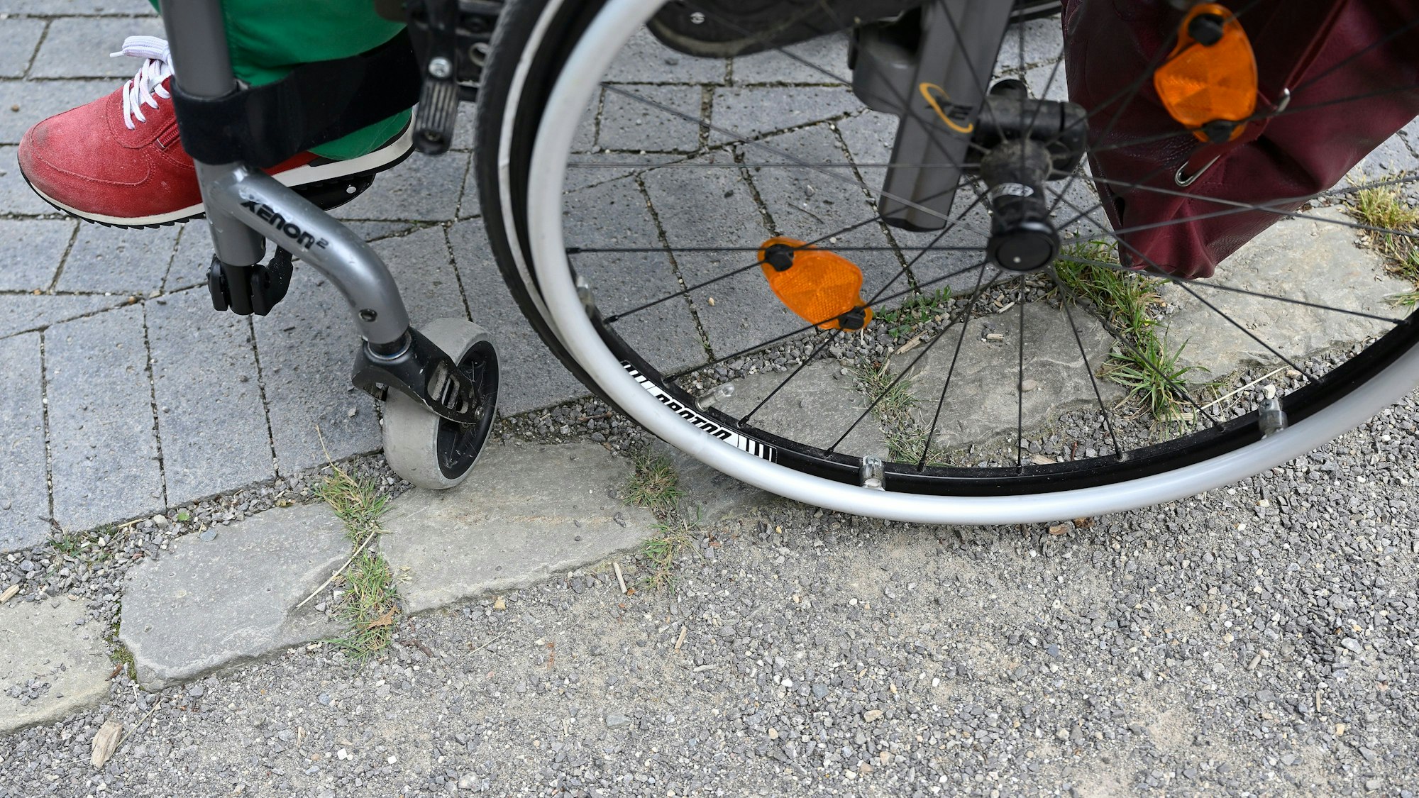 Ein Rollstuhl hat Schwierigkeiten, mit seinen Rädern die Kanten von Pflastersteinen zu überwinden.