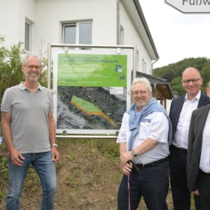 Fünf Männer stehen vor einer Schautafel, die den Bürgerwald in Steinenbrück erläutert.