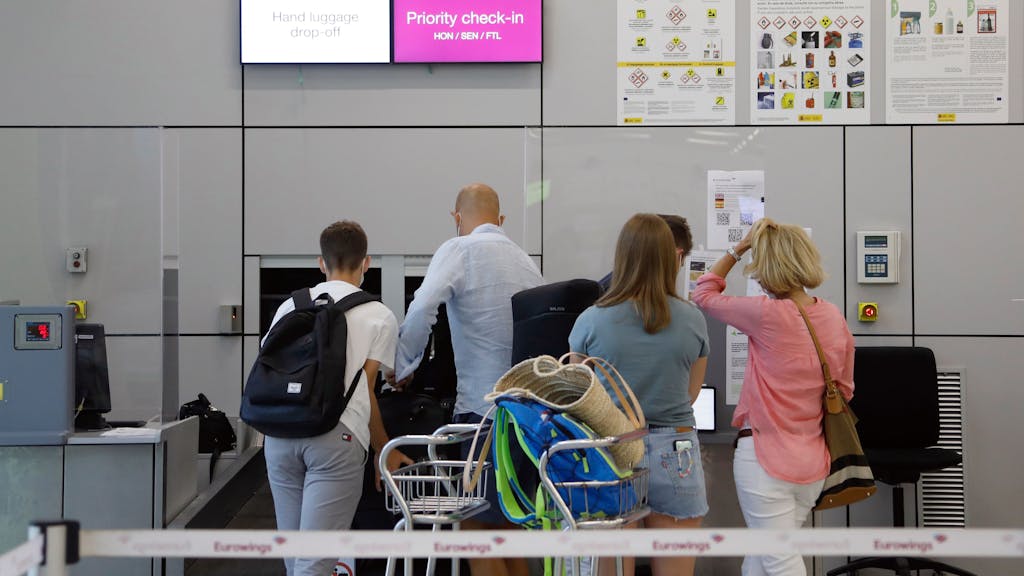 Fluggäste geben im Abflugbereich des Flughafens von Palma de Mallorca am Eurowings-Schalter ihre Koffer ab, hier im August 2021.