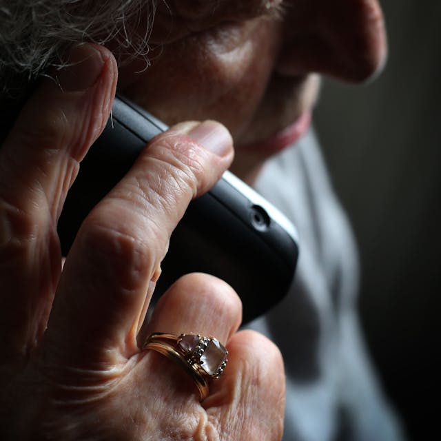 Eine ältere Frau telefoniert mit einem schnurlosen Festnetztelefon.&nbsp;