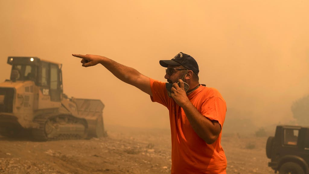 Ein freiwilliger Helfer gibt während eines Waldbrandes Anweisungen.&nbsp;