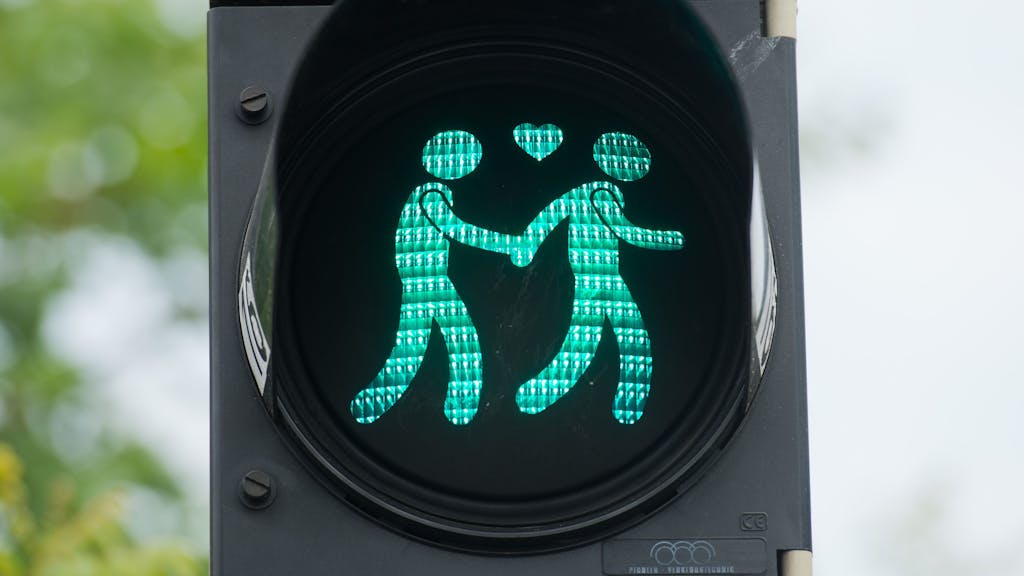 Eine Ampel, die grün leuchtet in München, mit schwulen Ampelmännchen.
