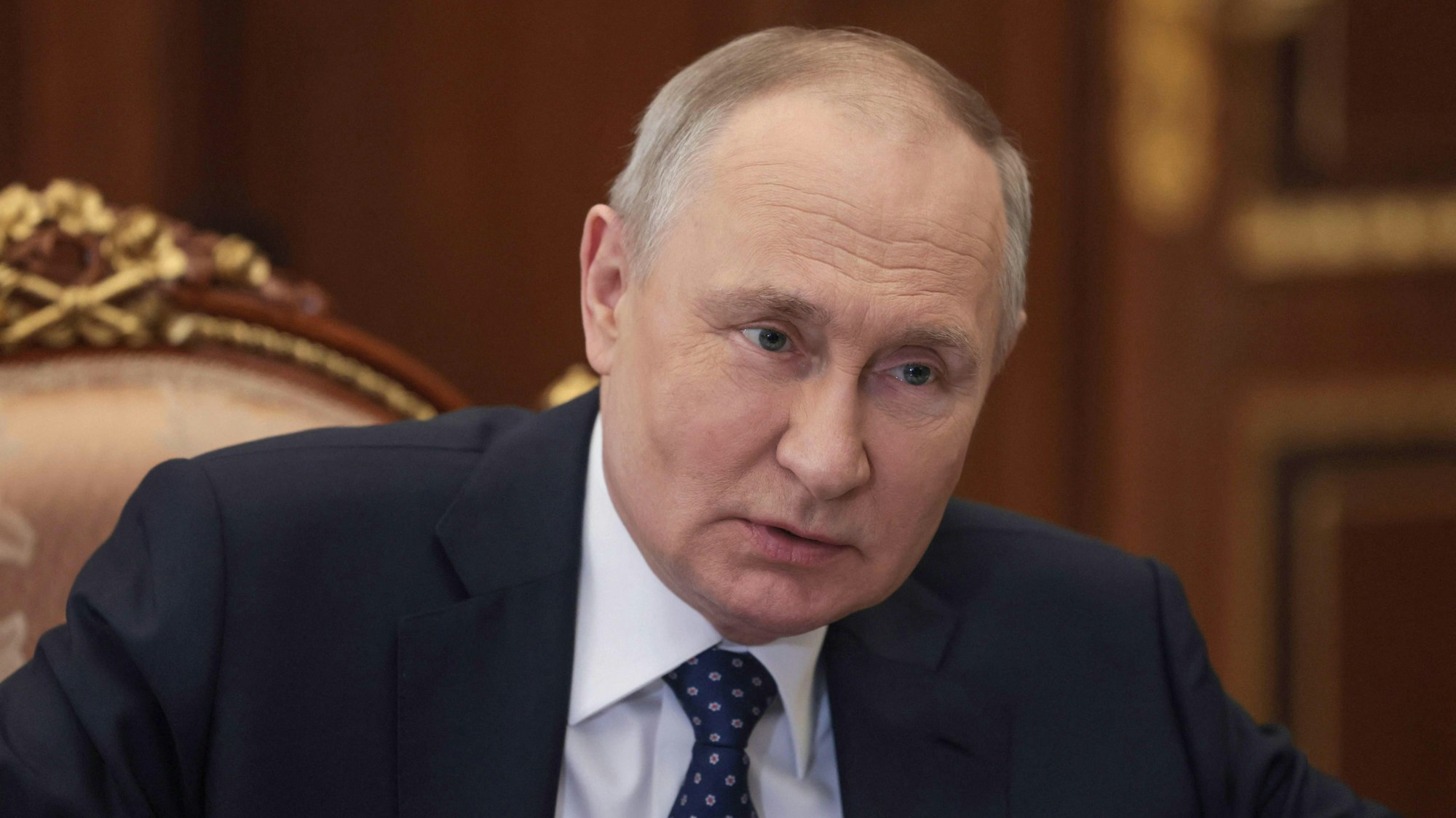 Der russische Präsident Wladimir Putin sitzt während einer Besprechung an einem langen Tisch im Kreml.