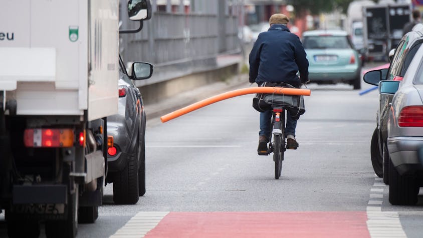 Ein Fahrradfahrer hat eine Schwimmnudel auf seinen Gepäckträger geklemmt. Damit will er auf den nötigen Sicherheitsabstand im Straßenverkehr hinweisen.&nbsp;