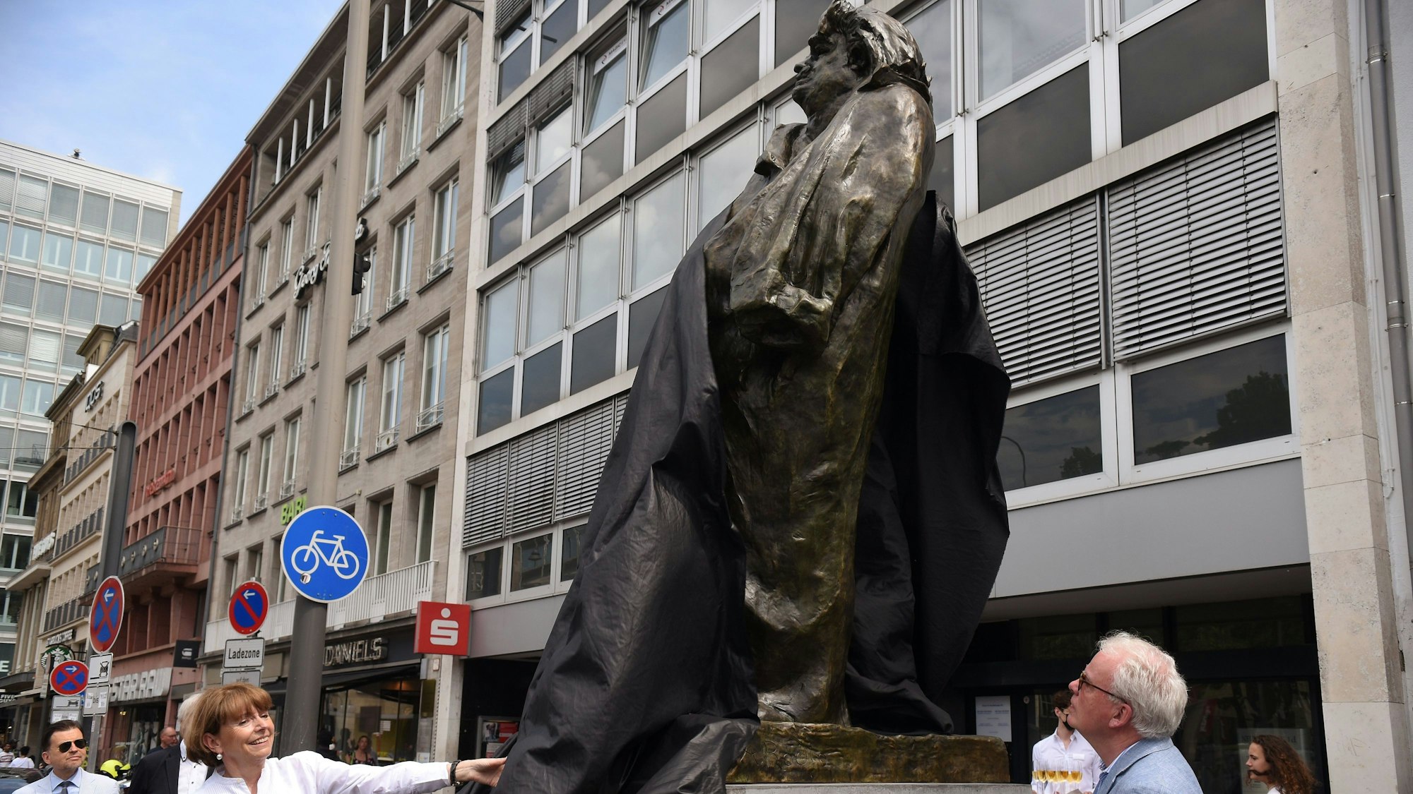 Oberbürgermeisterin Henriette Reker und Henrik Hanstein vom Kunsthaus Lempertz enthüllen die Rodin-Skulptur am Kölner Neumarkt.