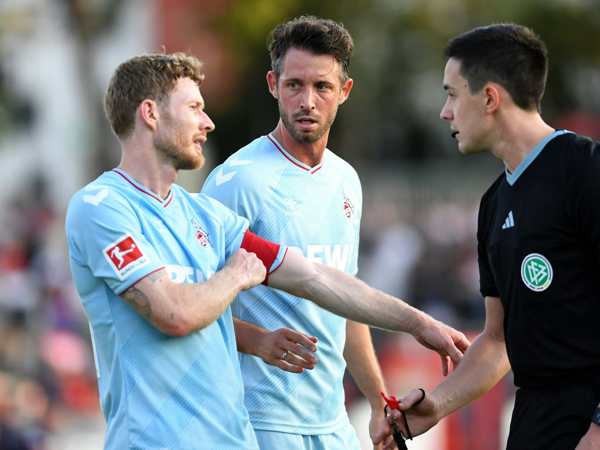 Der neue FC-Kapitän Florian Kainz (l.) und Mark Uth sprechen im Testspiel gegen Fortuna Köln mit dem Schiedsricher.
