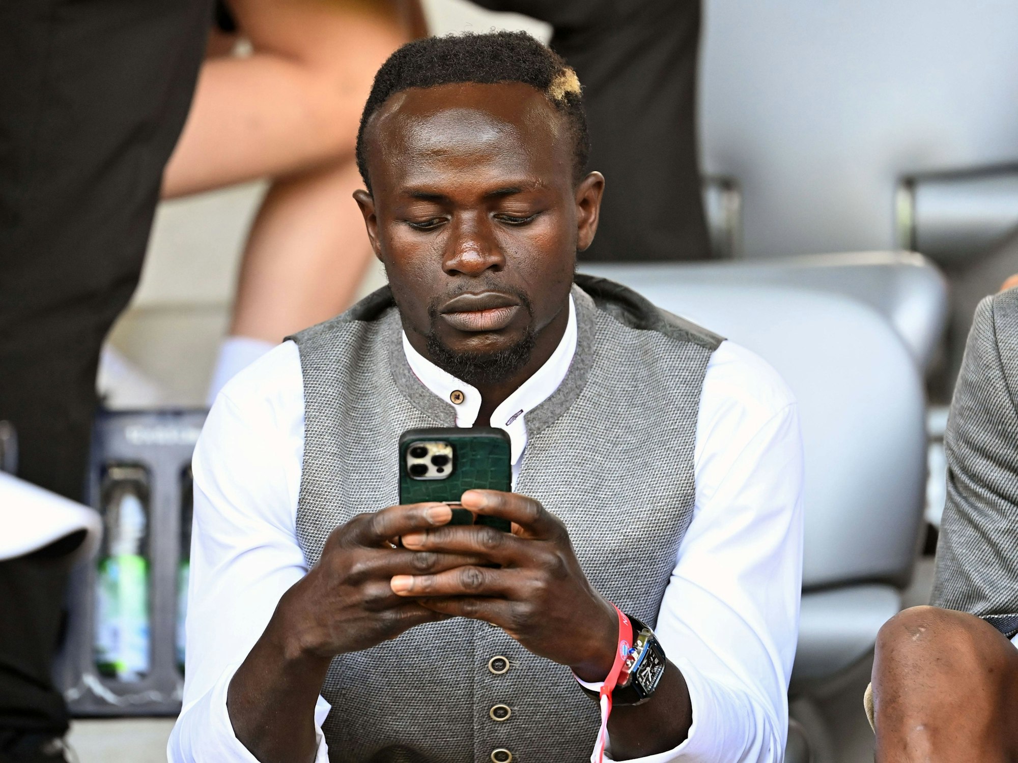 Sadio Mané schaut auf sein Smartphone.