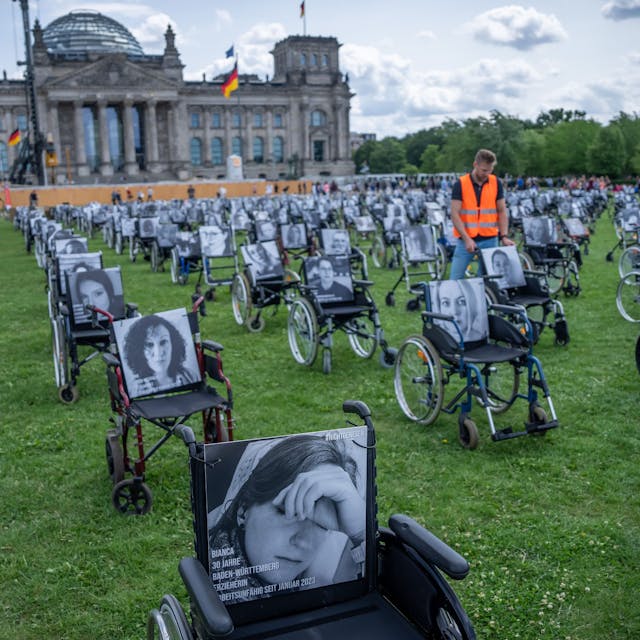 Aktion der Aktion „Nichtgenesen“ Anfang Juli vor dem Reichstag in Berlin. Auf den Rollstühlen stehen Bilder  mit Namen von Long Covid, ME/CFS und Post Vac- Betroffenen.