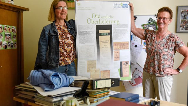 Das Bild zeigt Susanne Kremmer und Susanne Harke-Schmidt, die die ersten Ergebnisse zur Ausstellung zum Thema Archivarbeit zeigen.
