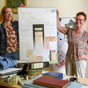 Das Bild zeigt Susanne Kremmer und Susanne Harke-Schmidt, die die ersten Ergebnisse zur Ausstellung zum Thema Archivarbeit zeigen.