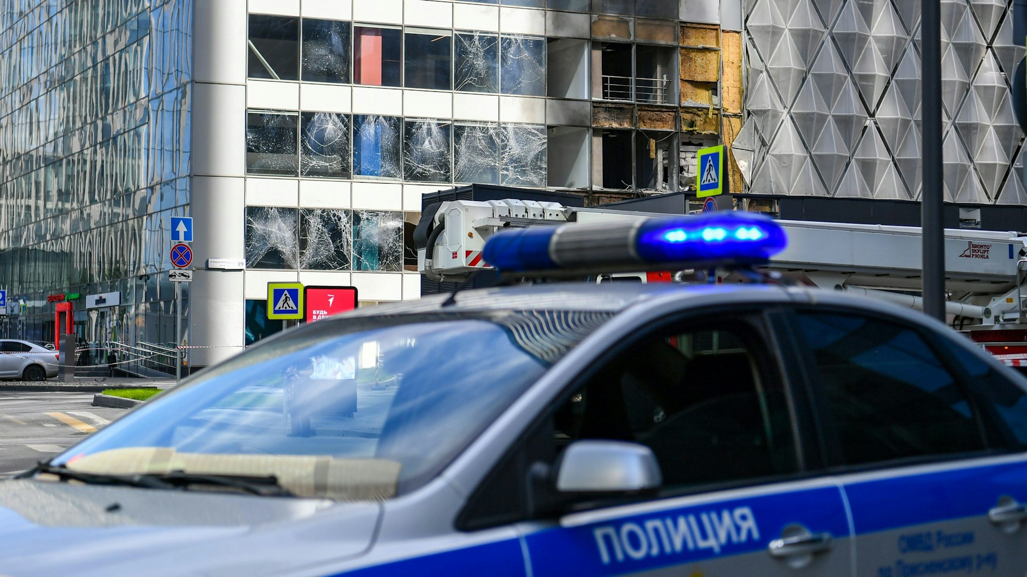 Eine Polizeiauto steht in der Nähe des Gebäudes, dass bei einem Drohnenangriff in Moskau beschädigt wurde.