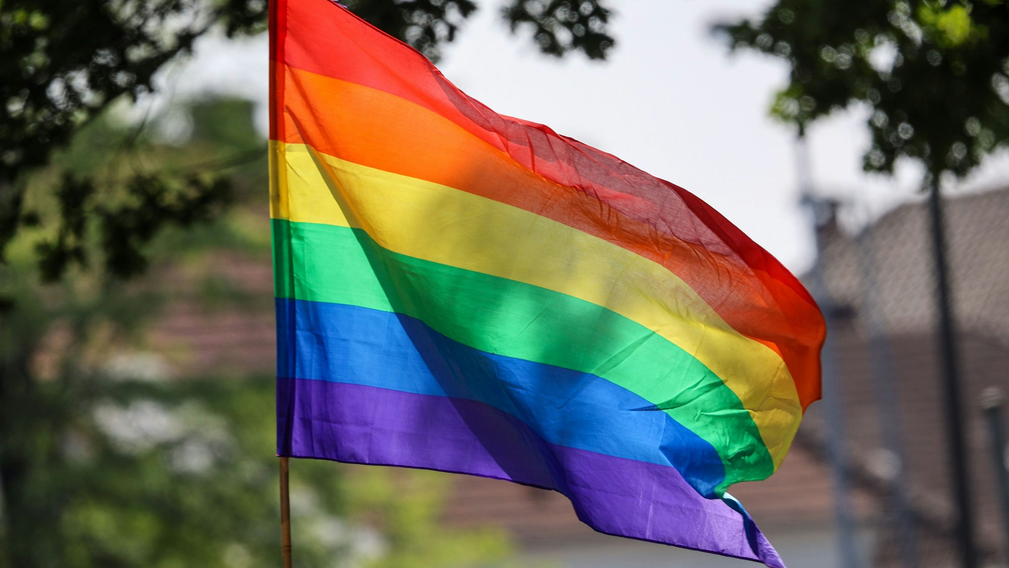 Eine Regenbogenfahne weht beim Umzug zum Christopher Street Day (CSD) im Wind.
