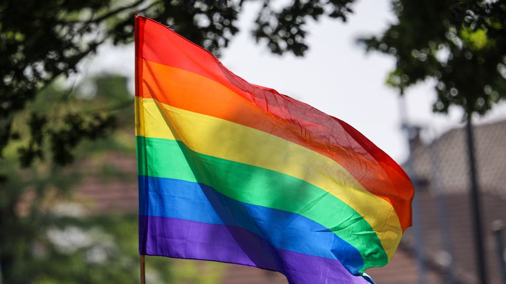 Eine Regenbogenfahne weht beim Umzug zum Christopher Street Day (CSD) im Wind.