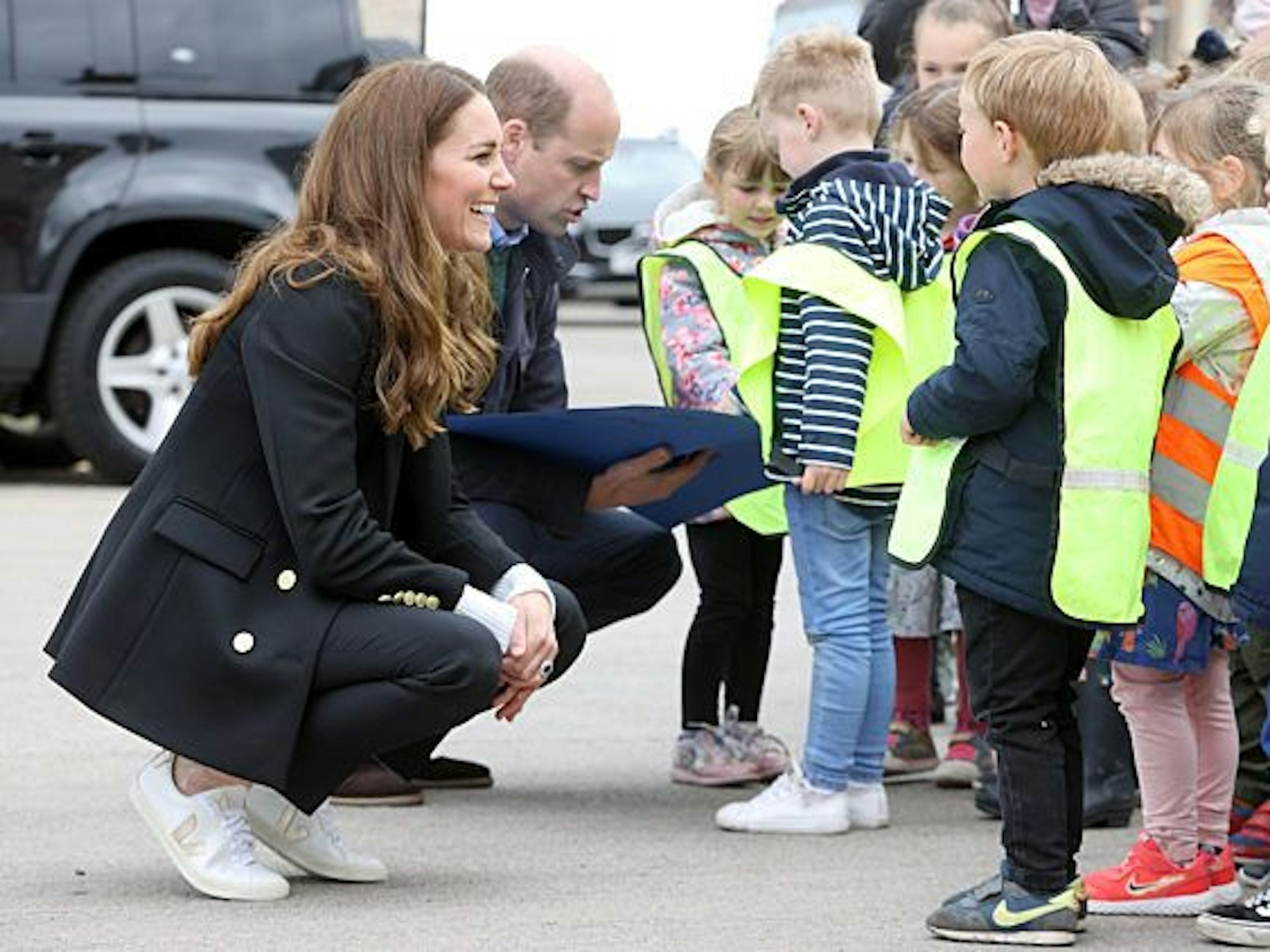 Kate, Herzogin von Cambridge, und Prinz William, Herzog von Cambridge, unterhalten sich bei ihrem Besuch der schottischen Council Area Fife mit jungen Kindern.