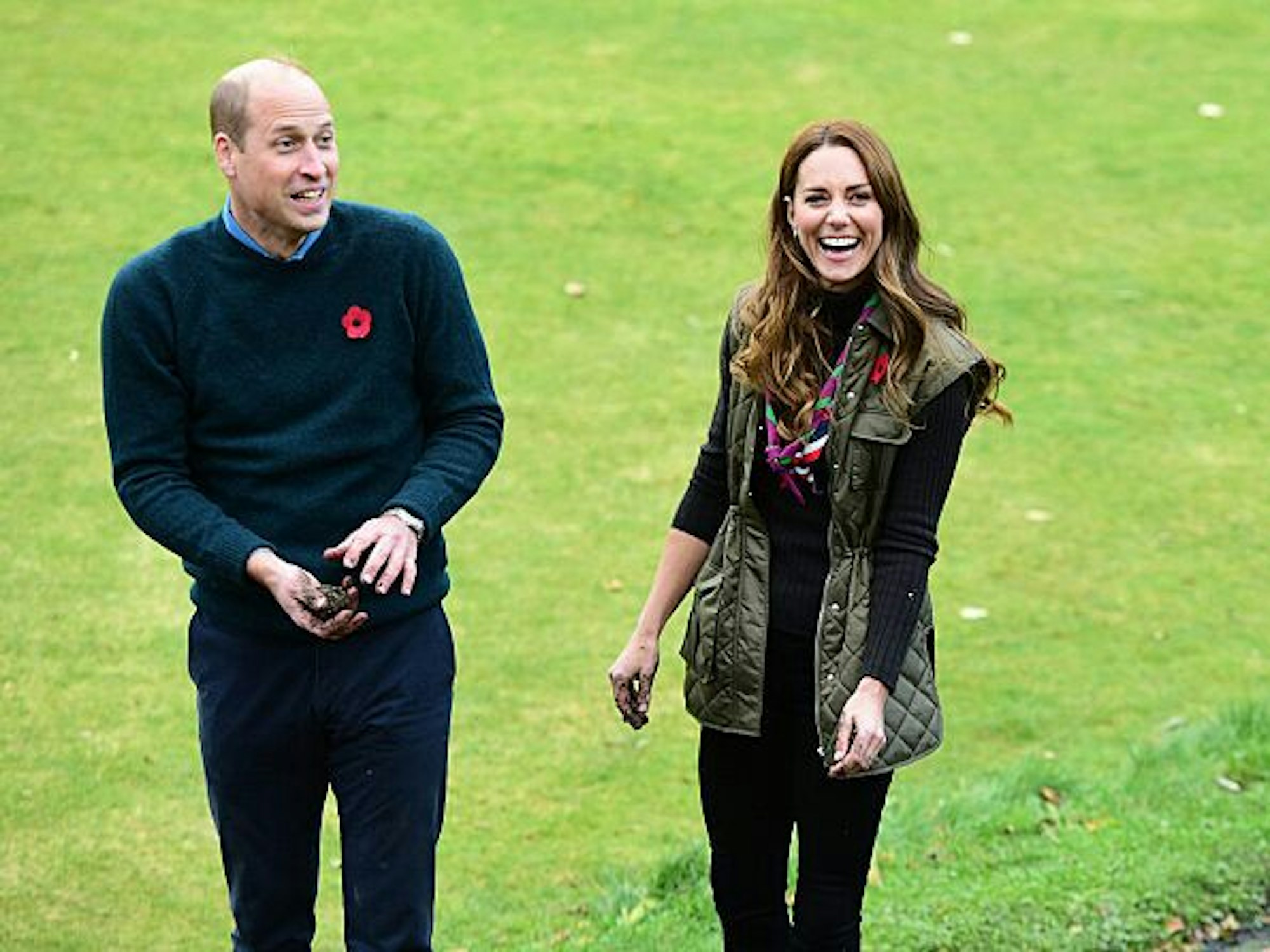 Der britische Prinz William, Herzog von Cambridge, und Catherine, Herzogin von Cambridge, lachen nach dem Werfen von Samenbomben, während eines Besuchs zur Feier der Pfadfinderkampagne "PromiseToThePlanet" im Alexandra Park Sports Hub.