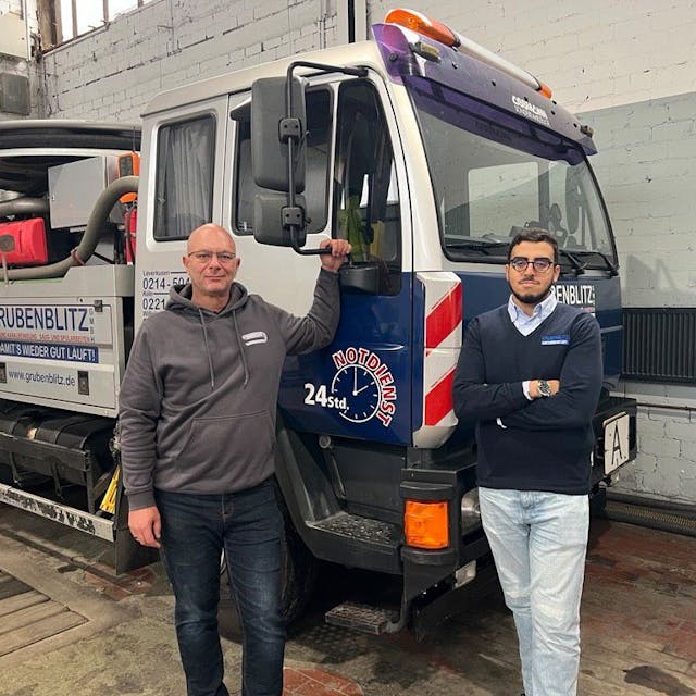 Boumadiane Ousrout (r.) und sein Ausbildungsleiter Lothar Thome vor einem Einsatzwagen der Grubenblitz GmbH