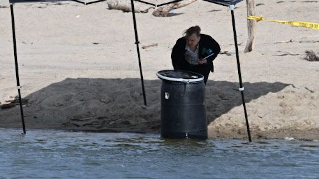 Ein Beamter steht neben einem Fass, in dem am 31. Juli 2023 am Malibu Lagoon State Beach in Kalifornien eine Leiche entdeckt wurde.