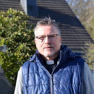 Der alt-katholische Geistliche Michael Schenk stammt aus Waldbröl und gehört zu den Opfern sexuellen Missbrauchs durch katholische Geistliche. Hier sitzt er an einem Rondell vor seinem Therapie- und Exerzitien-Hof Aim Karem in Ruppichteroth-Stranzenbach.