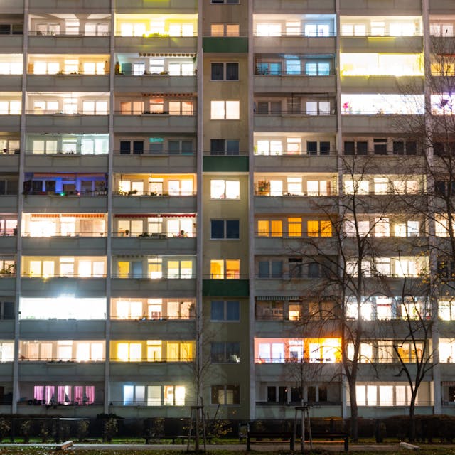 In einem Hochhaus sind einige Fenster beleuchtet.