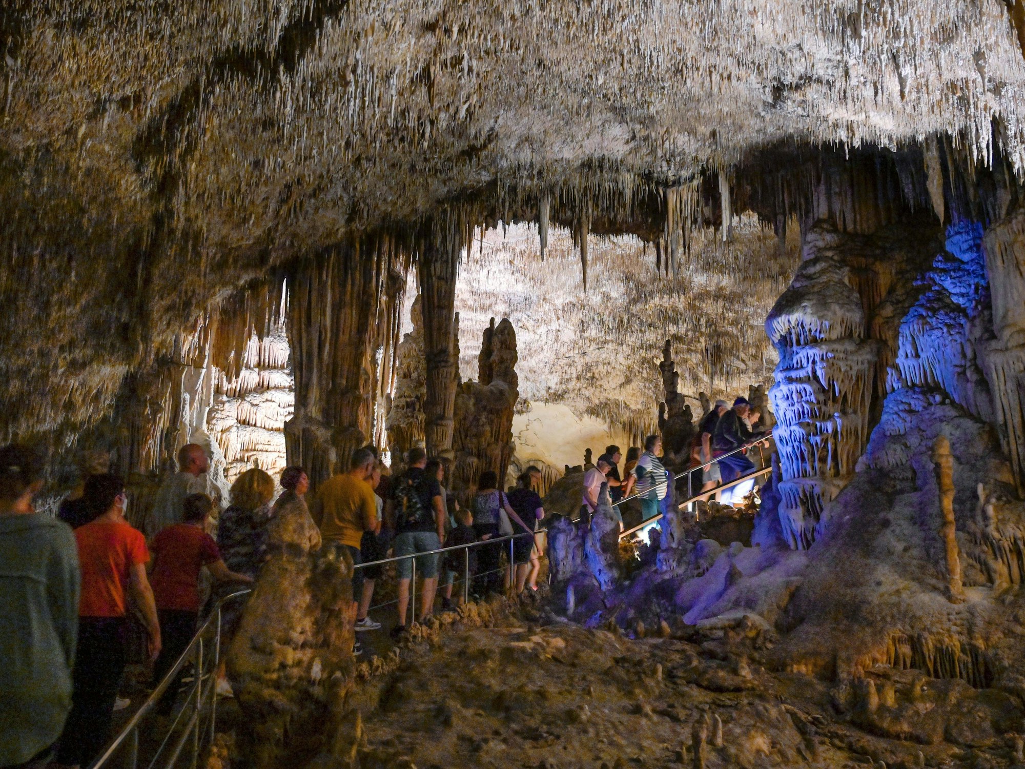 Touristinnen und Touristen gehen im Oktober 2022 durch die Tropfsteinhöhle in Spanien.