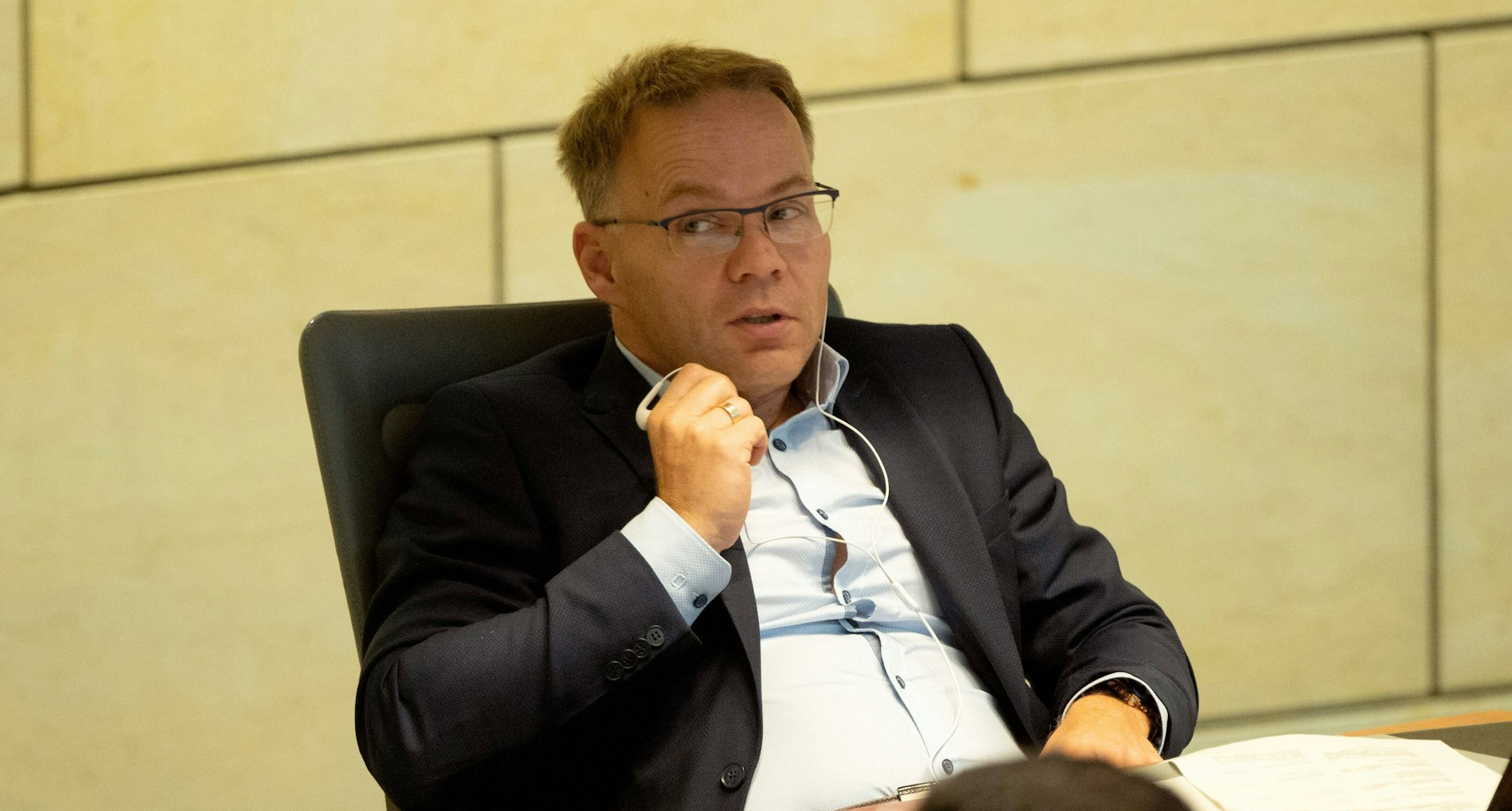 Der fraktionslose Christian Blex bei der 12. Sitzung des Landtags Nordrhein-Westfalen. Er sitzt auf einem Sessel, trägt Anzug und Brille.