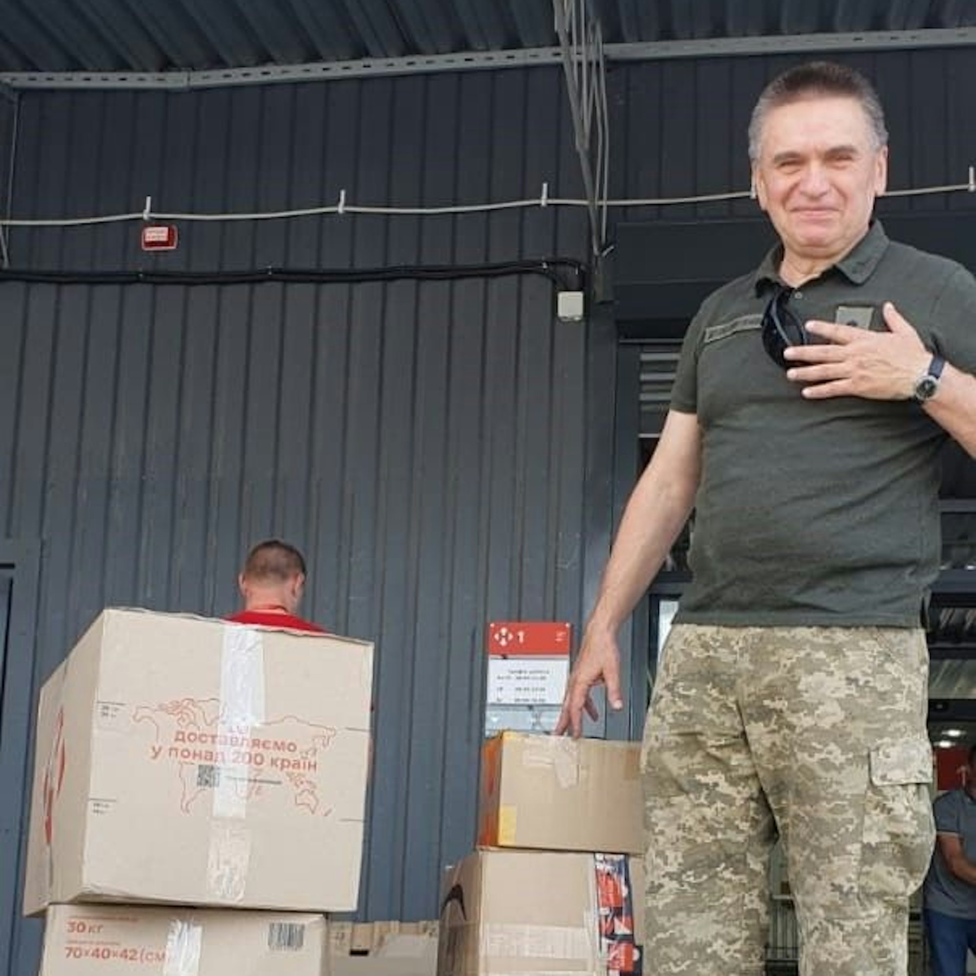 Ein ukrainischer Soldat stet neben mehreren Kisten.